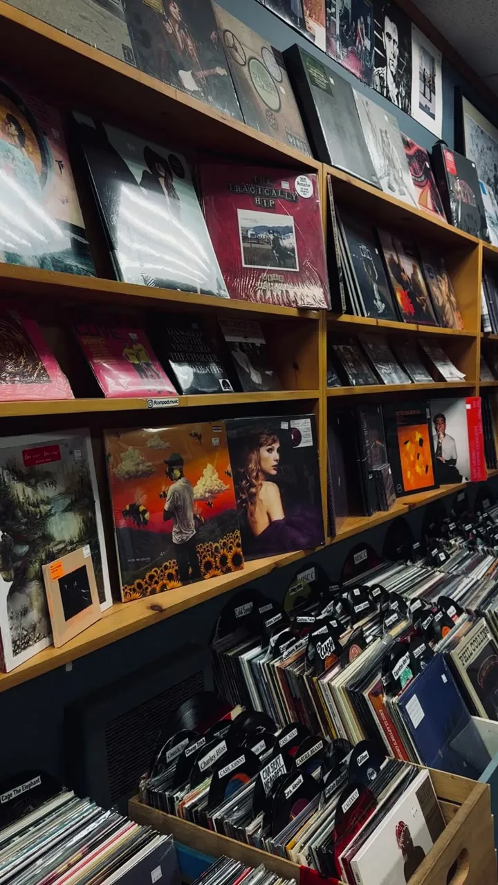 Shelves packed with books and record sleeves in a shop.