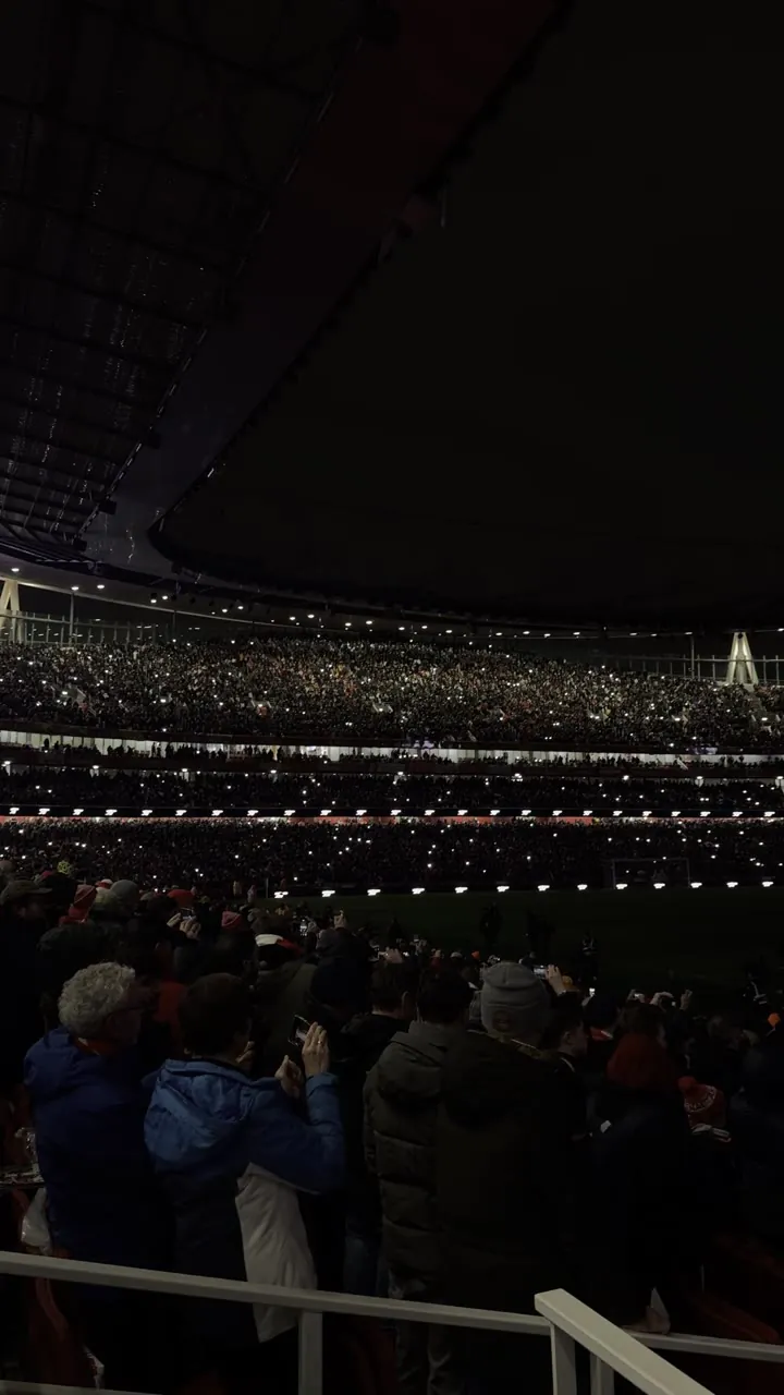 Crowd at night under rows of string lights.