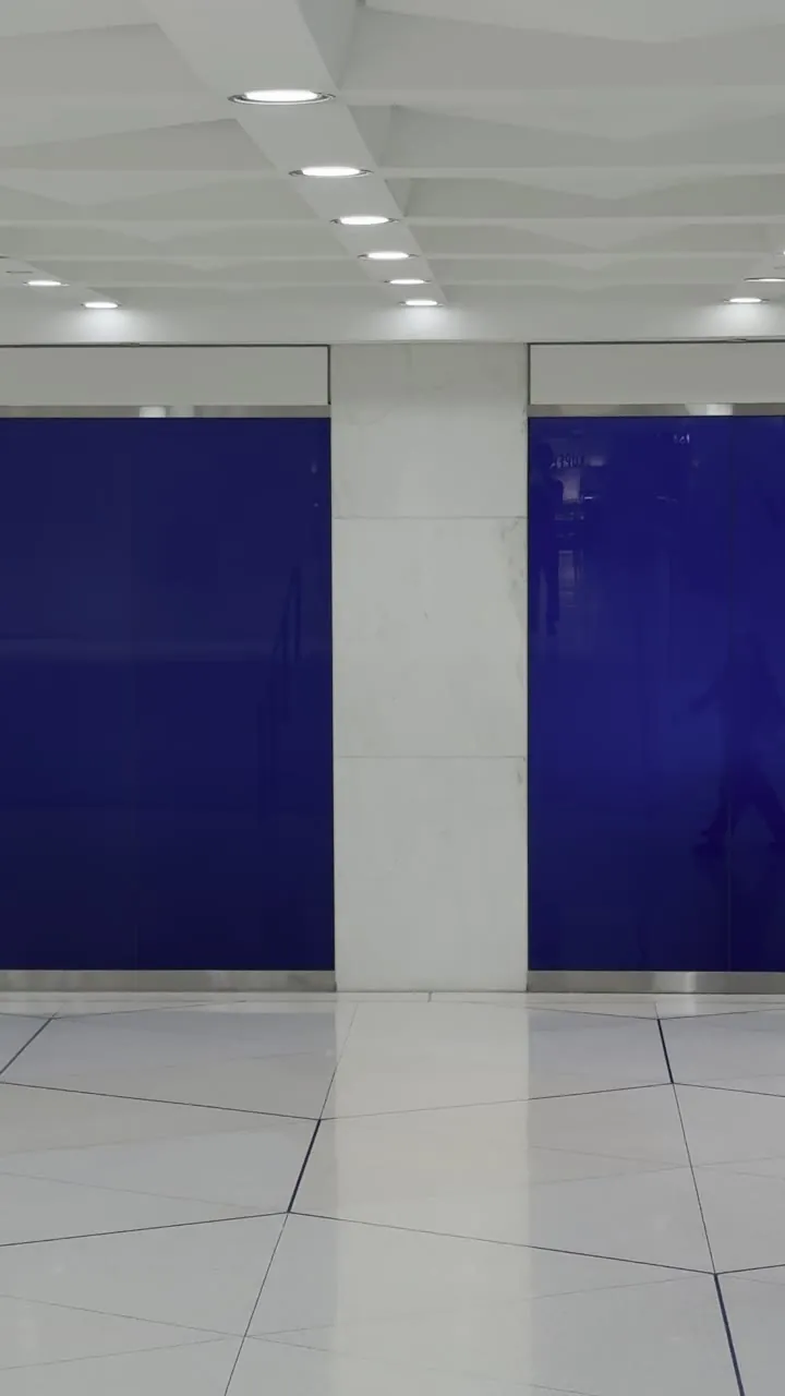 Bright hallway with blue panels and a person walking.