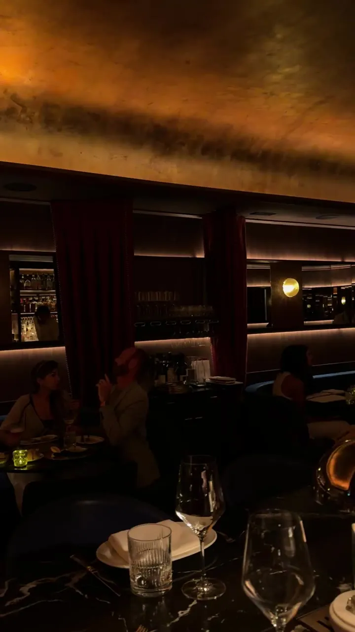 Dimly lit restaurant interior with glasses on a table.
