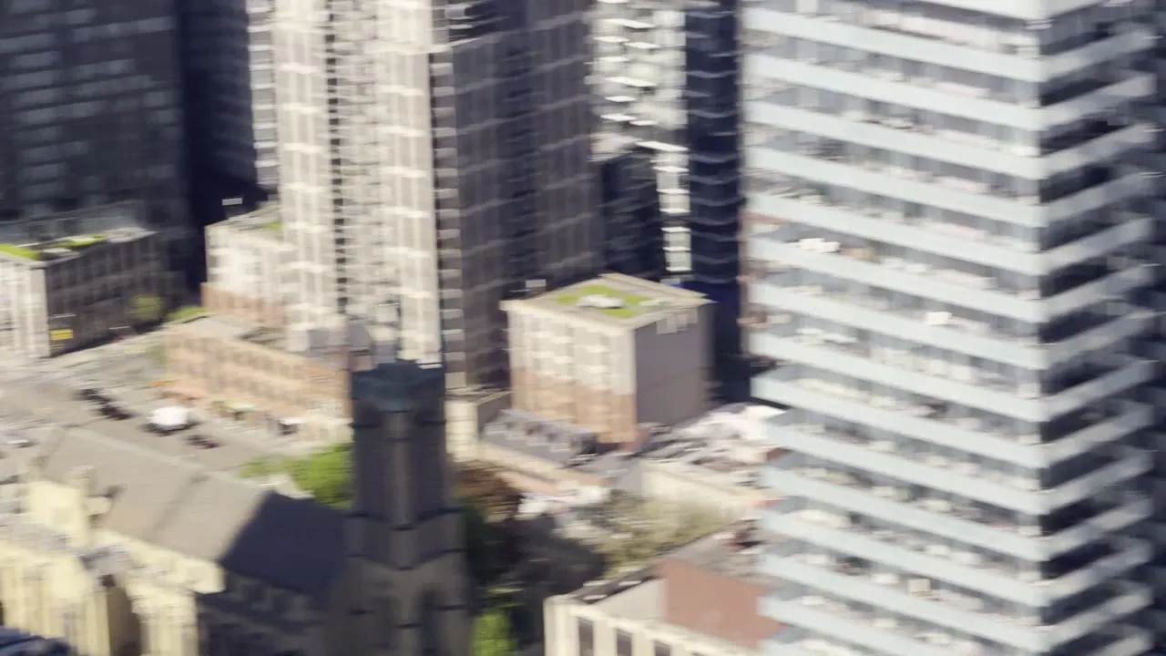 High view of tall condo towers and low rooftops in a city.
