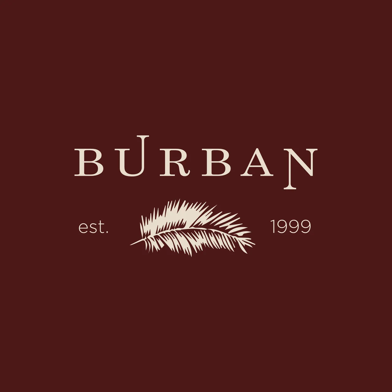 Burban Clothing crest with a palm frond, cream on burgundy.