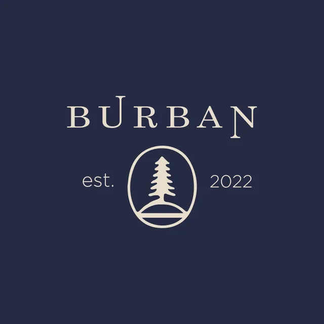 Burban Clothing crest with a pine tree in a circular badge, cream on navy.