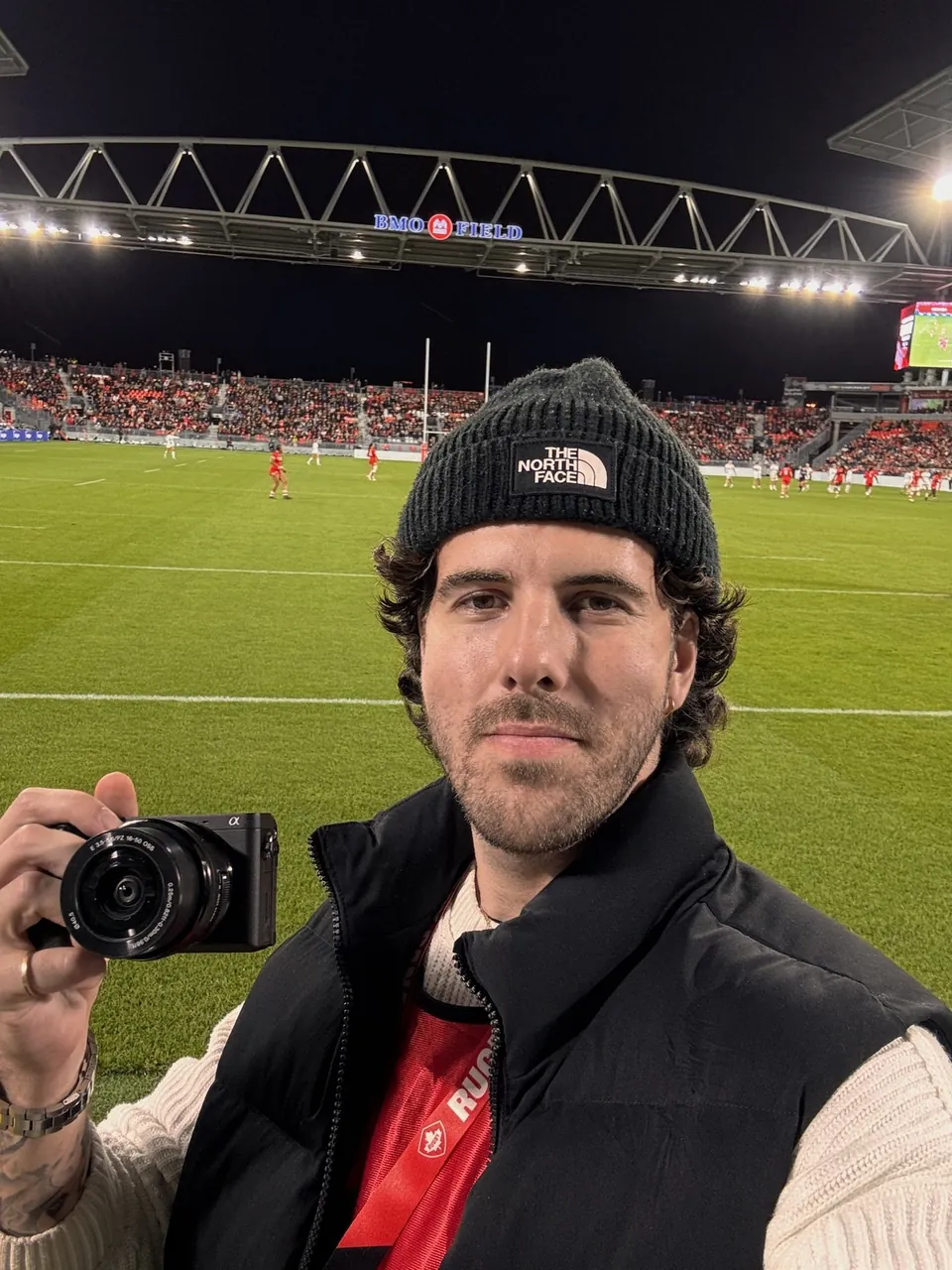 Austin Werner holding a camera field-side at BMO Field during the match.